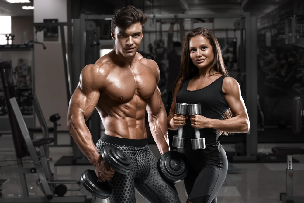 Sporty Sexy Couple Showing Muscle And Workout In Gym Muscular